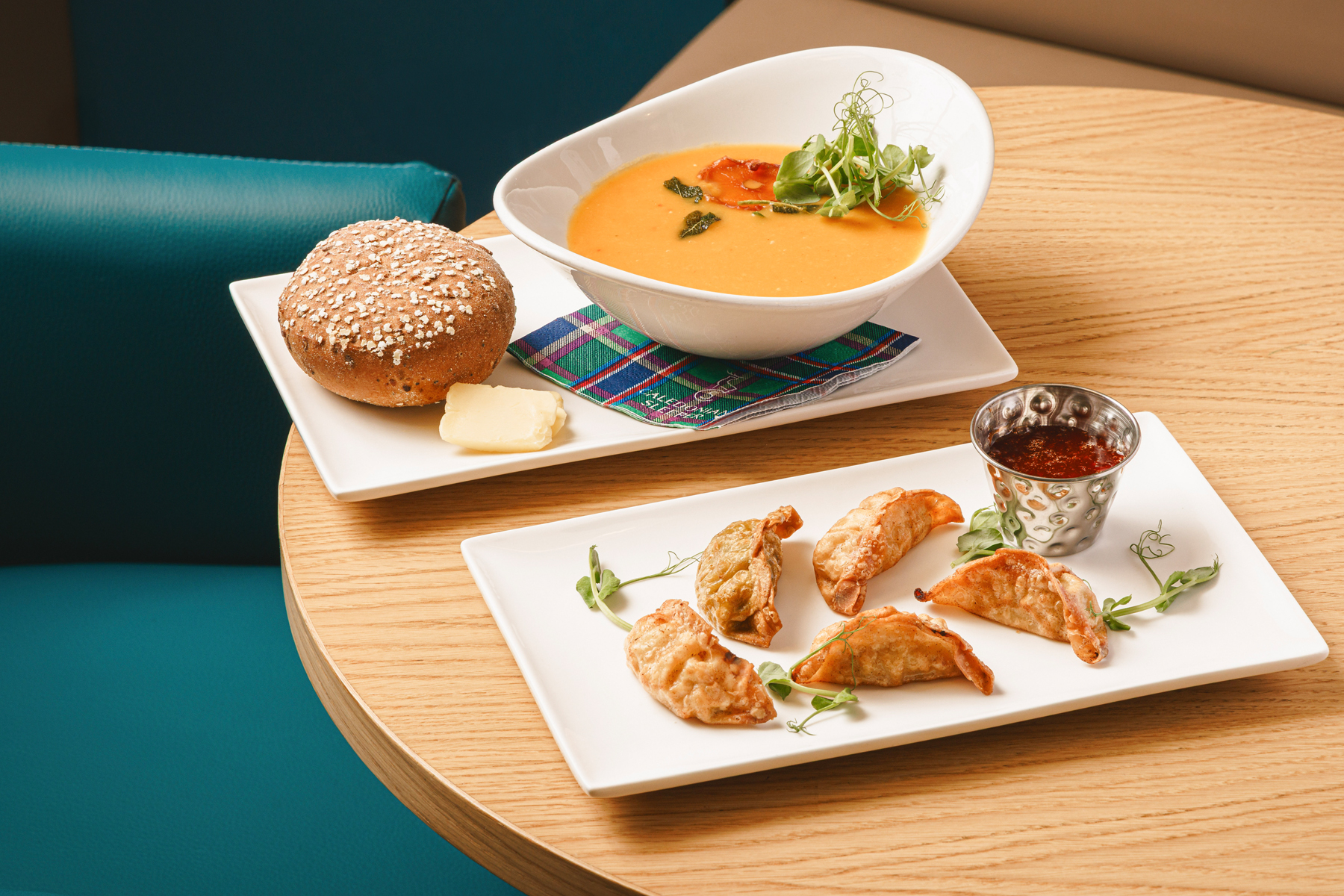 Selection of starters including a bowl of soup and a plate of gyozas. 